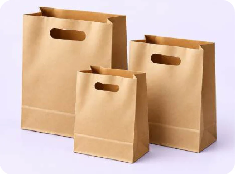 Tres bolsas kraft de fondo cuadrado, con un asa troquelada ovalada en la parte alta, de tres tamaños y la más chica al frente